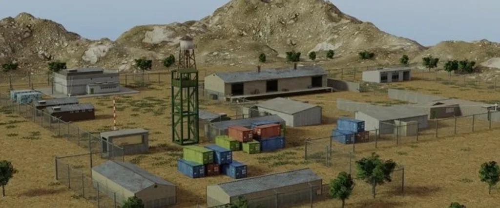 Project IGI  A fenced military base surrounded by desert terrain and mountains, featuring storage containers, guard towers, and various buildings.

